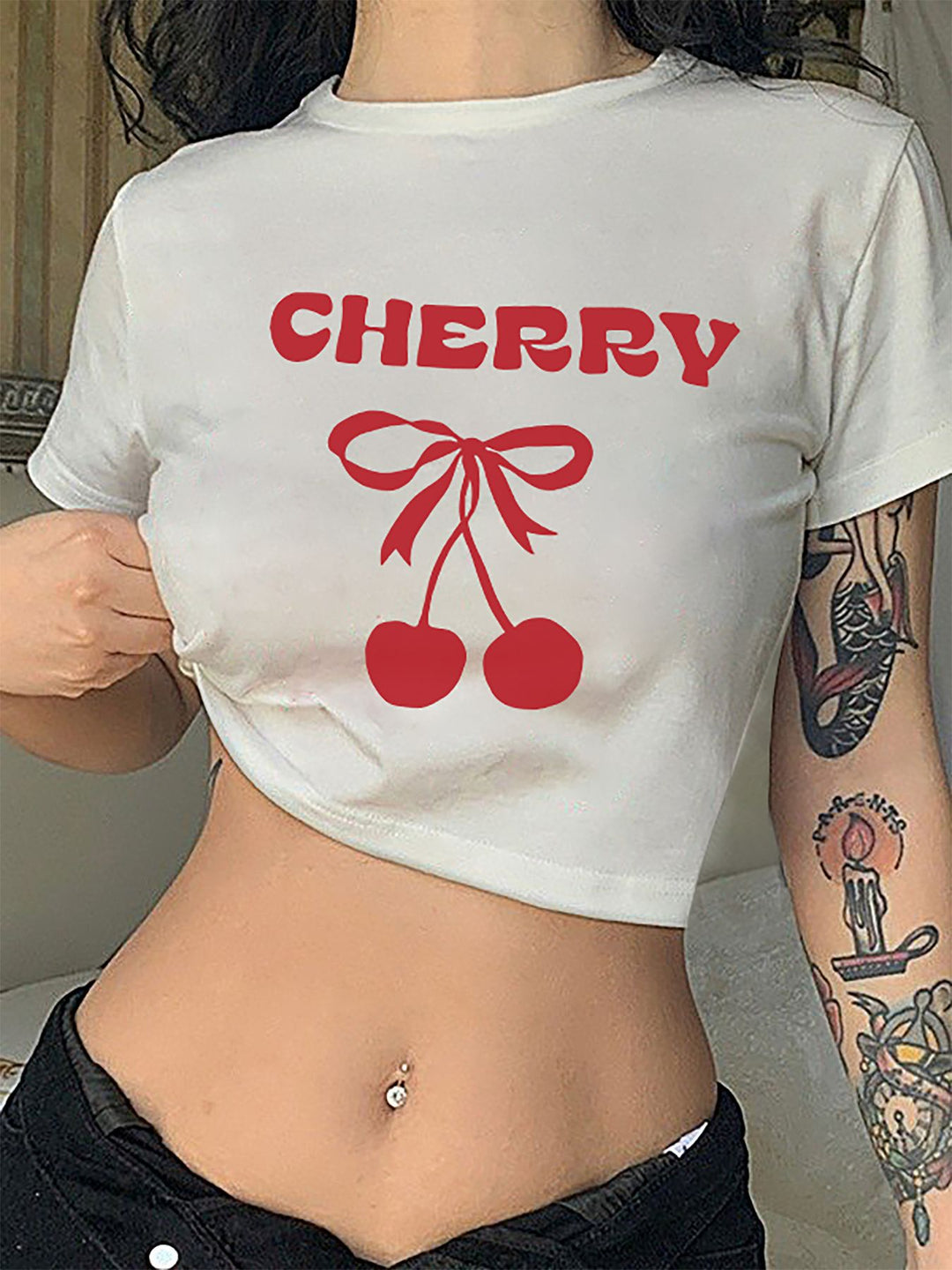 Dame Crop-T-shirt med lekfullt körsbärsmotiv och elegant rosetttryck Mirla-Eva Jonsson