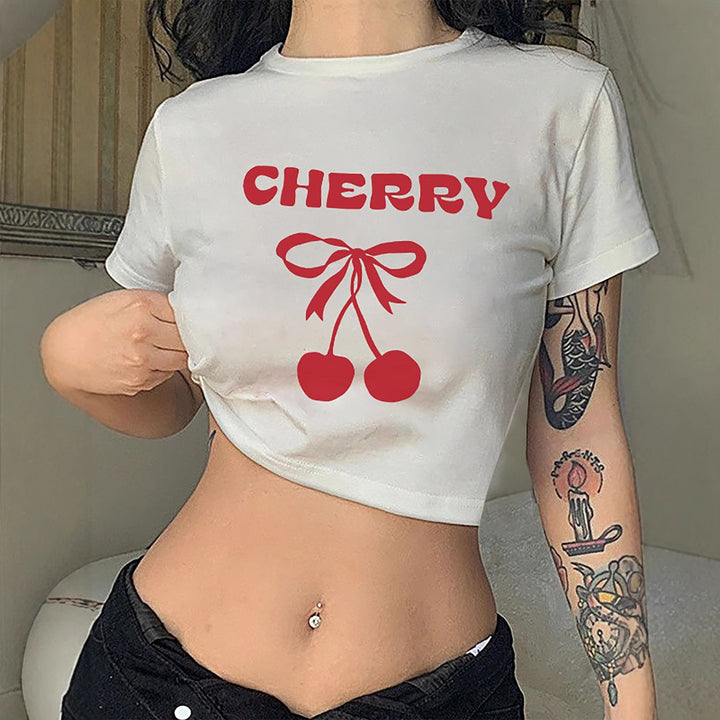 Dame Crop-T-shirt med lekfullt körsbärsmotiv och elegant rosetttryck Mirla-Eva Jonsson