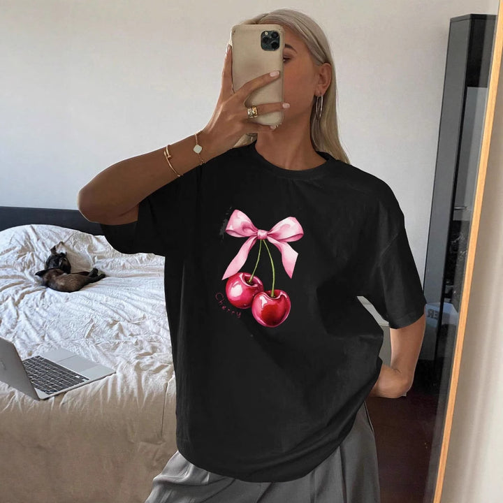 Dame T-shirt med fruktig körsbärsmotiv och lekfull detalj med rosett Mirla-Eva Jonsson