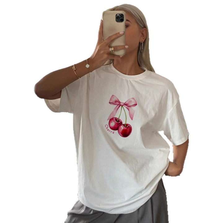 Dame T-shirt med fruktig körsbärsmotiv och lekfull detalj med rosett Mirla-Eva Jonsson