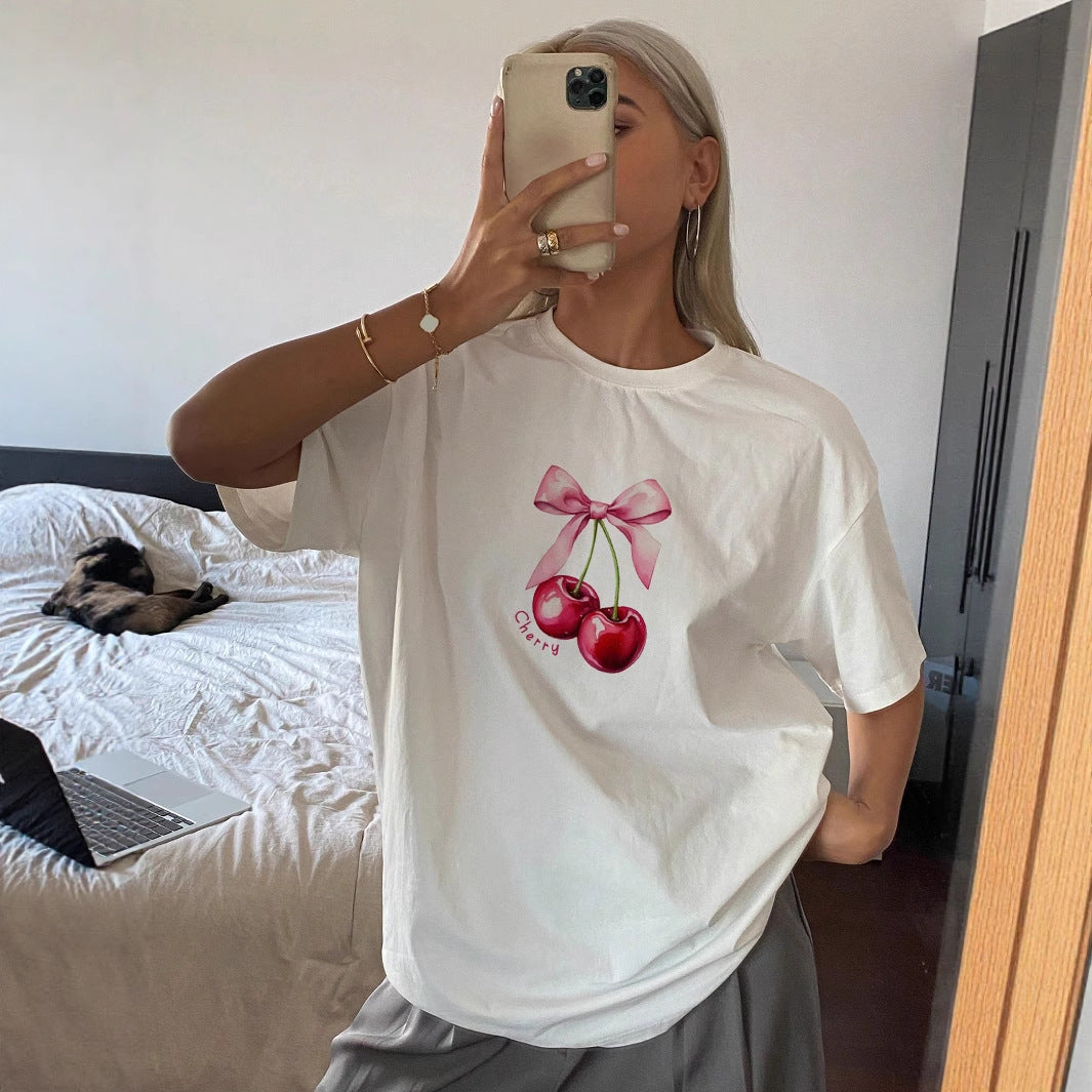 Dame T-shirt med fruktig körsbärsmotiv och lekfull detalj med rosett Mirla-Eva Jonsson