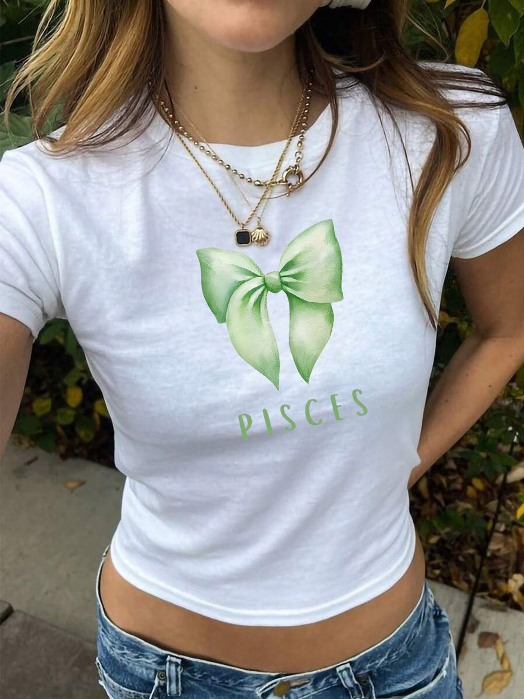 Dame crop-top med charmigt sløyfmotiv och astrologisk tryck Mirla-Eva Jonsson