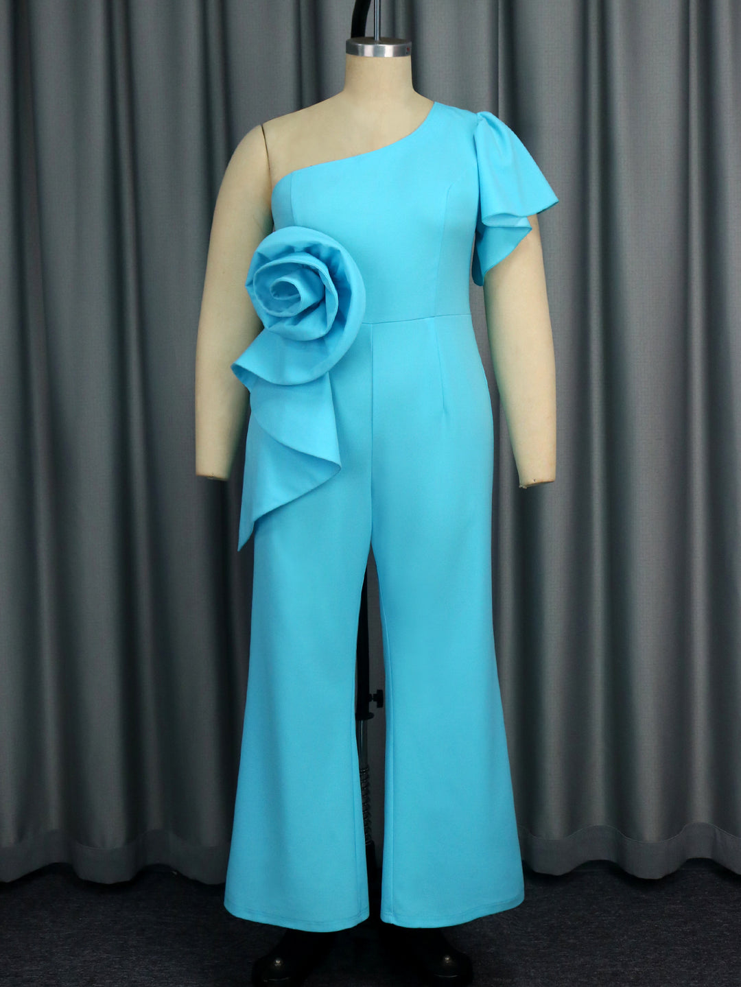 Dame jumpsuit med asymmetrisk skärning och voluminös blomsteraccent Mirla-Eva Jonsson