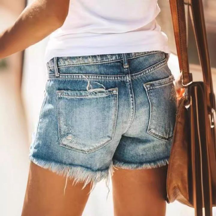 Dame trendiga förstörda denimshorts med fransade fållar och modiga rissdetaljer Mirla-Eva Jonsson