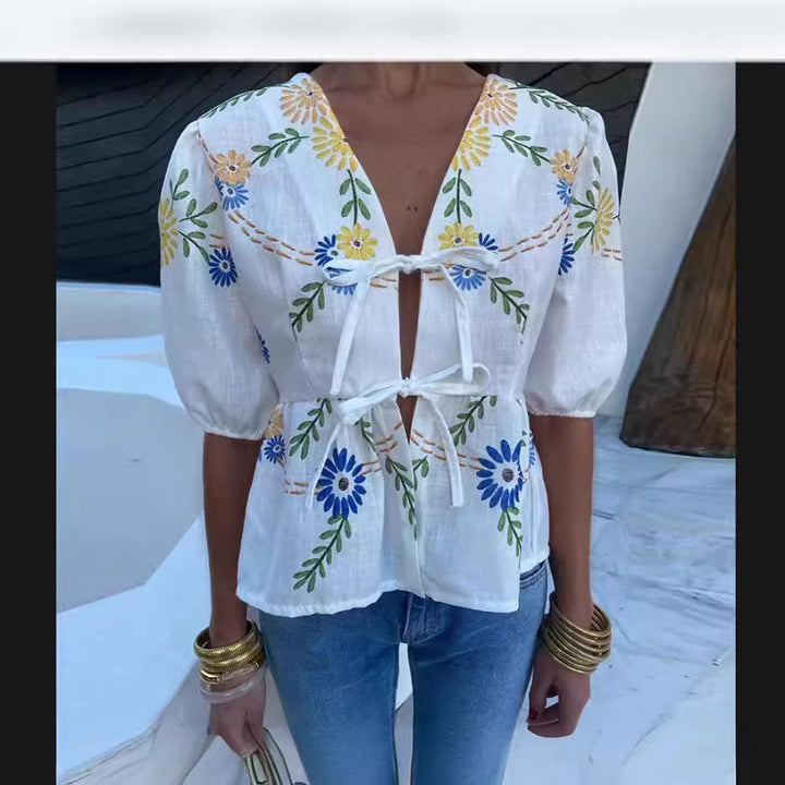 Dameblus med blommiga broderier och lekfull snitt Mirla-Eva Jonsson