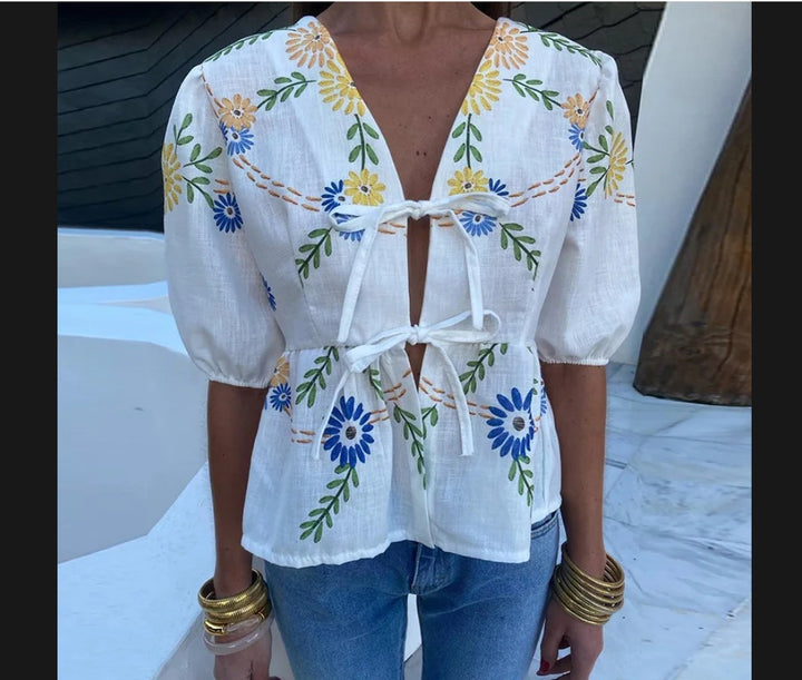 Dameblus med blommiga broderier och lekfull snitt Mirla-Eva Jonsson