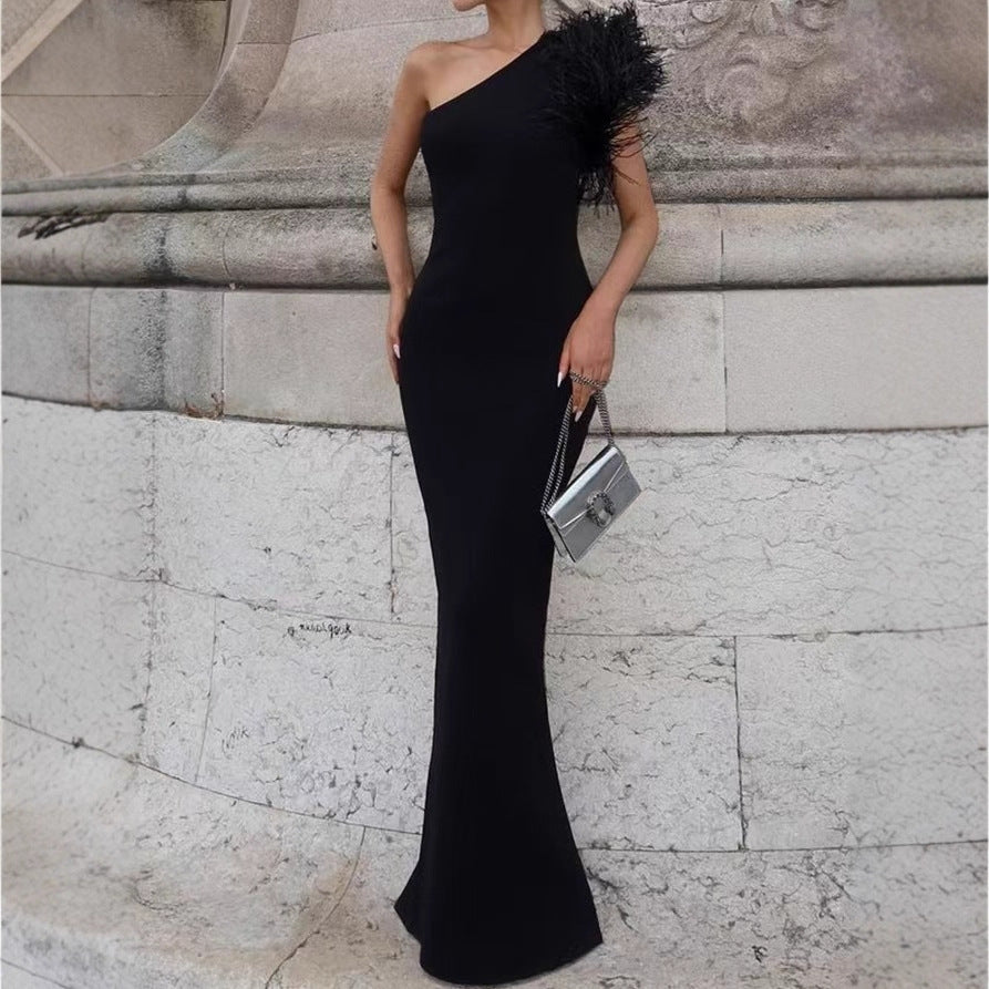 Damer Elegant aftonklänning med asymmetrisk skärning och konstfullt fjäderdekorer Mirla-Eva Jonsson