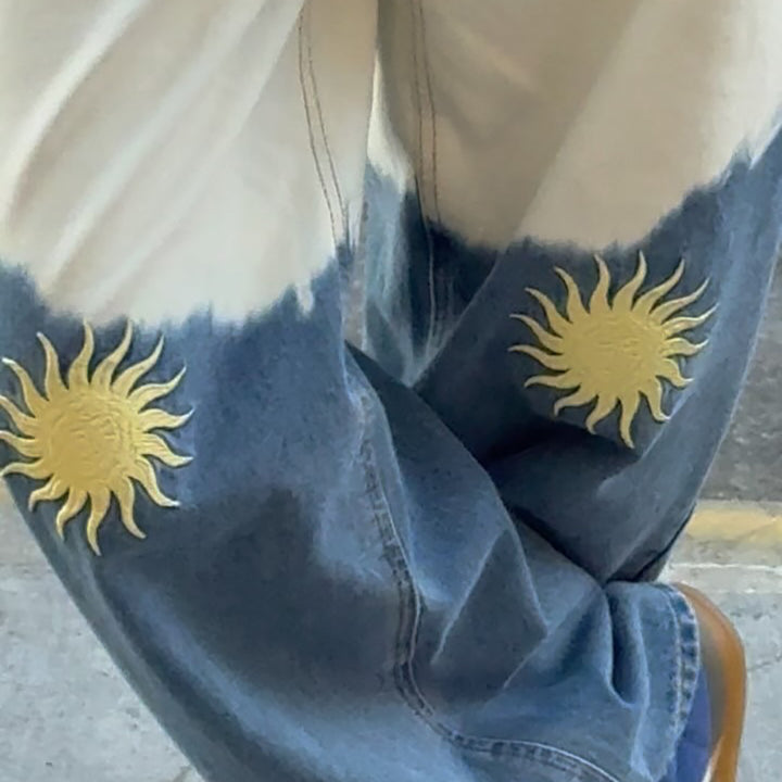Damer vida denimbyxor med kreativa solbroderier Mirla-Eva Jonsson