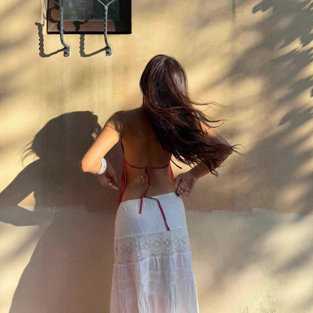 Damern halterneck topp med djup V-urringning och tilltalande slinga-detalj Mirla-Eva Jonsson