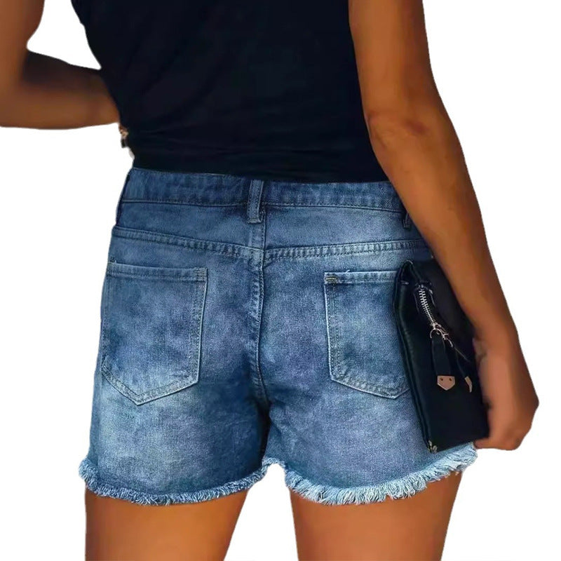 Damern trasiga denimshorts med fransiga fickor och moderiktiga lappar Mirla-Eva Jonsson