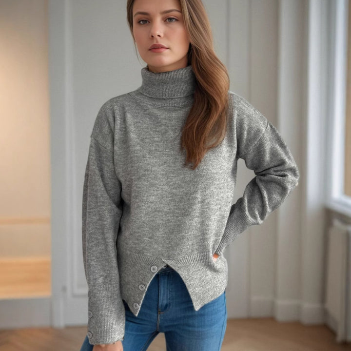 Damernas moderiktiga rullkragepullover med knappr detaljer och asymmetrisk fåll Mirla-Eva Jonsson