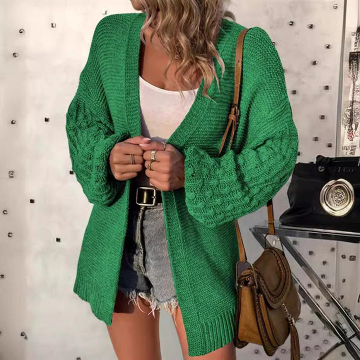 Damernas moderiktiga stickad cardigan med voluminösa ärmar och öppen design Mirla-Eva Jonsson