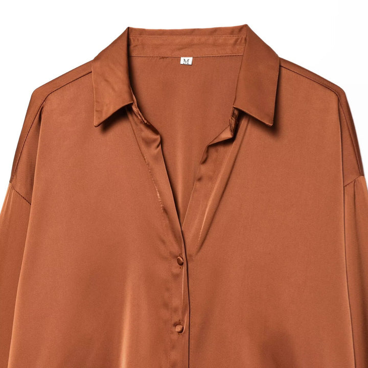 Damsilkeblus med eleganta fjädrar vid ärmsluten Mirla-Eva Jonsson