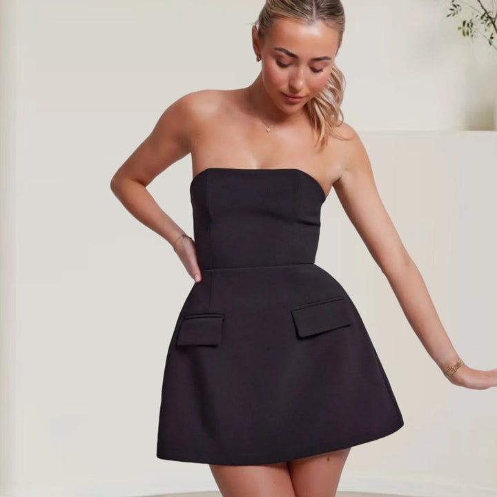 Kvinnor elegant bandeau-klänning med strukturerad kjol och praktiska fickor Mirla-Eva Jonsson