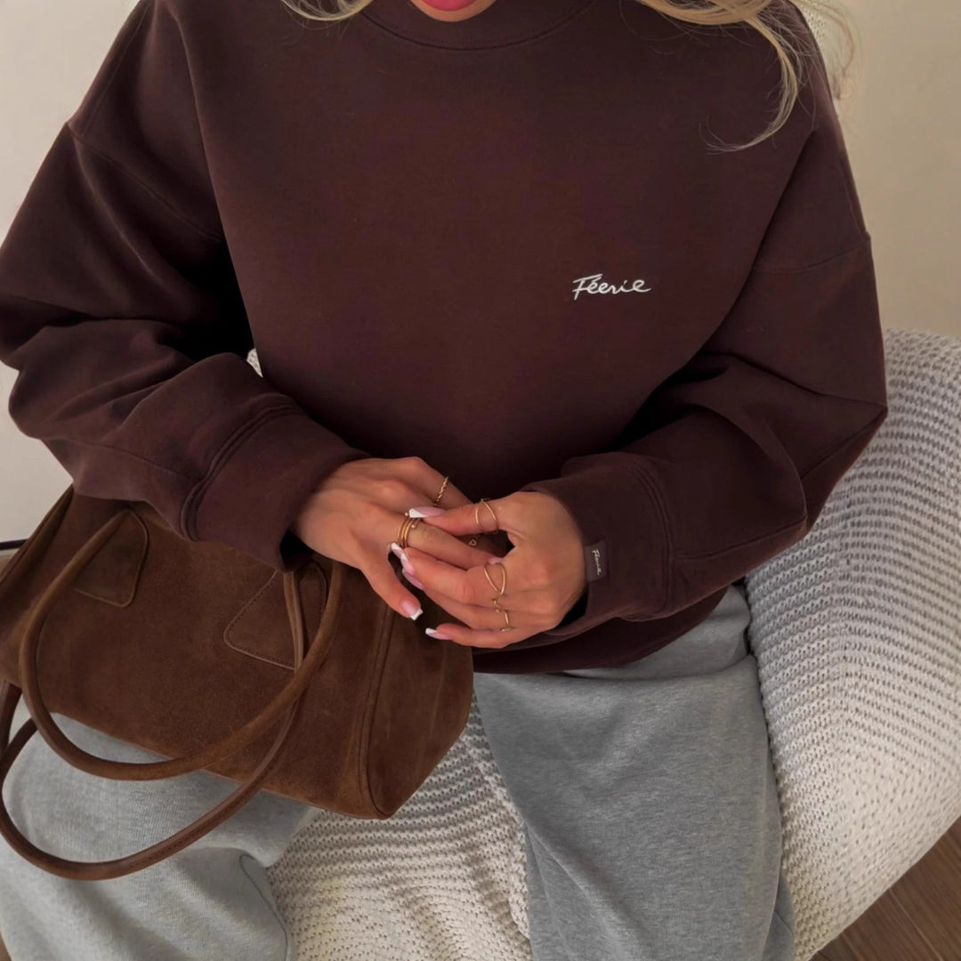 Kvinnors avslappnad oversized tröja med rund hals och diskret logotyp Mirla-Eva Jonsson