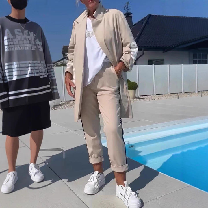 Kvinnors avslappnad trenchcoat med trendiga ränder och stiliga bokstäver Mirla-Eva Jonsson