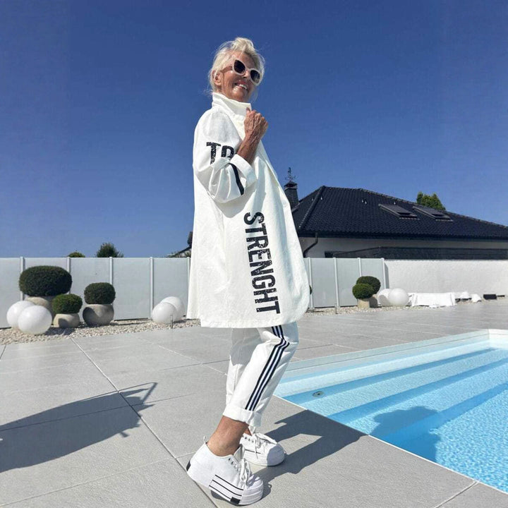 Kvinnors avslappnad trenchcoat med trendiga ränder och stiliga bokstäver Mirla-Eva Jonsson