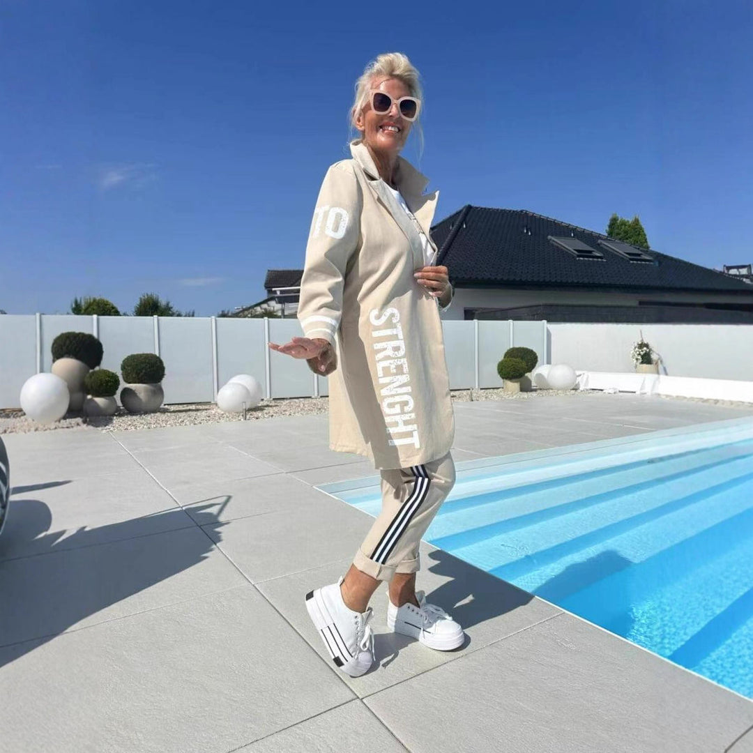 Kvinnors avslappnad trenchcoat med trendiga ränder och stiliga bokstäver Mirla-Eva Jonsson