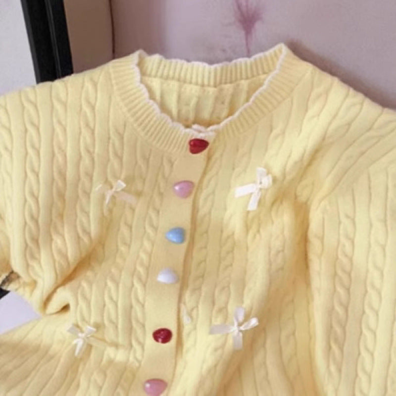 Kvinnors chunky stickad cardigan med lekfulla knapppdetaljer och rosetter-Eva Jonsson