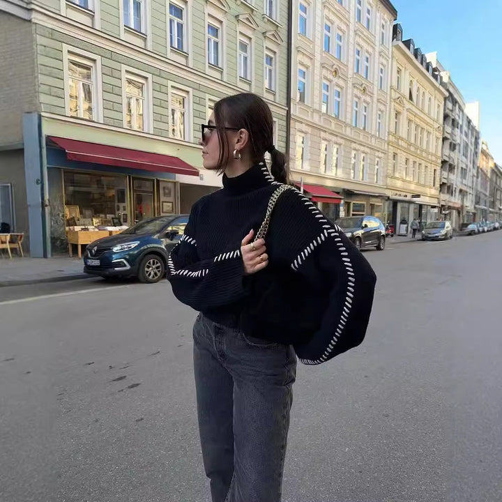 Kvinnors chunky stickad tröja med hög krage och eleganta ärmdetaljer Mirla-Eva Jonsson