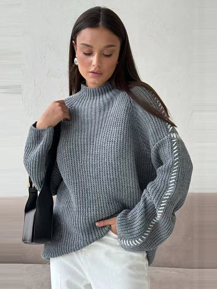 Kvinnors chunky stickad tröja med hög krage och eleganta ärmdetaljer Mirla-Eva Jonsson