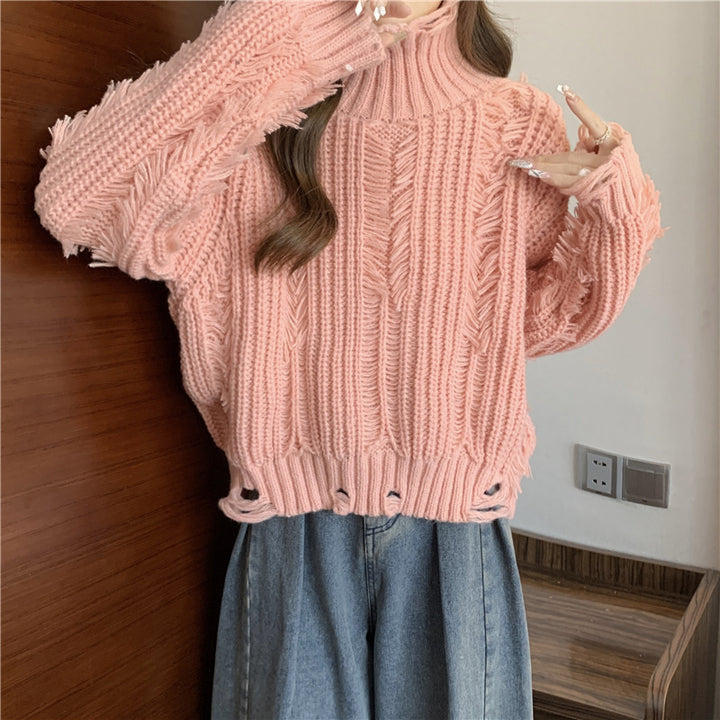 Kvinnors chunky stickad tröja med hög krage och fransade designelement Mirla-Eva Jonsson