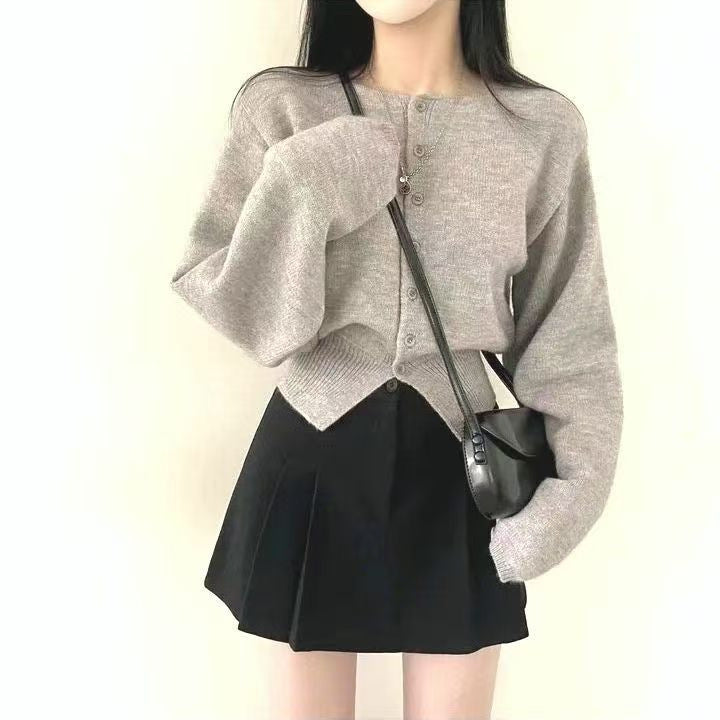 Kvinnors crop sweater med knappdetalj och oversized ärmar Mirla-Eva Jonsson