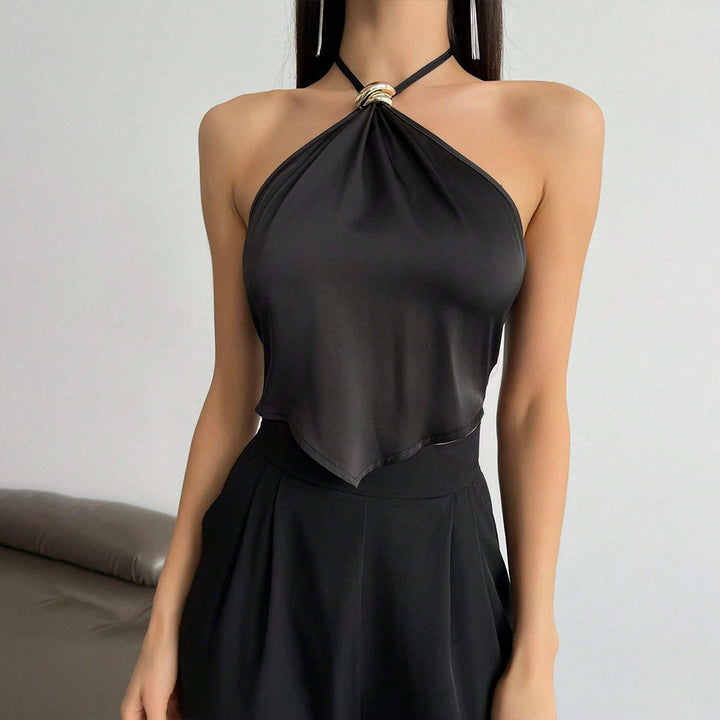Kvinnors elegant halterneck-top med blänkande tyg och dekorativ knut Mirla-Eva Jonsson