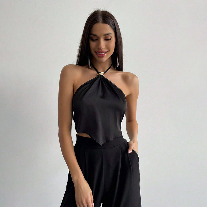 Kvinnors elegant halterneck-top med blänkande tyg och dekorativ knut Mirla-Eva Jonsson
