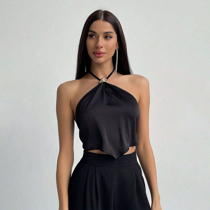 Kvinnors elegant halterneck-top med blänkande tyg och dekorativ knut Mirla-Eva Jonsson
