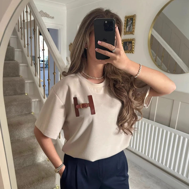 Kvinnors fashionabla t-shirt med unik logodetalj och avslappnad passform-Eva Jonsson