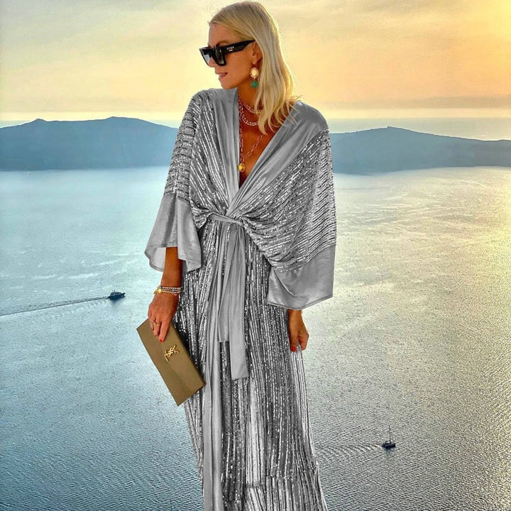 Kvinnors glittrande maxiklänning med elegant omslagdesign och flödande ärmar-Eva Jonsson