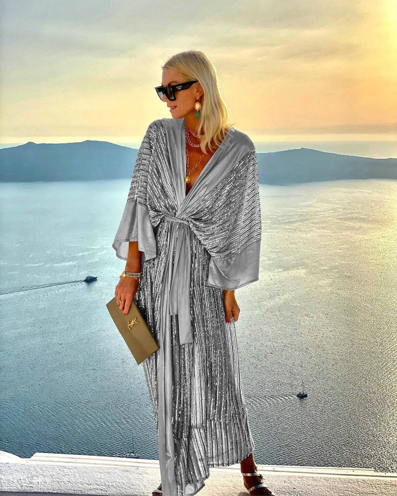 Kvinnors glittrande maxiklänning med elegant omslagdesign och flödande ärmar-Eva Jonsson