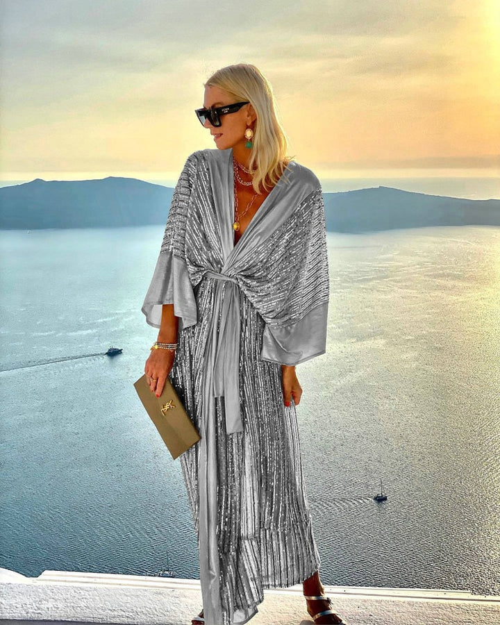 Kvinnors glittrande maxiklänning med elegant omslagdesign och flödande ärmar-Eva Jonsson