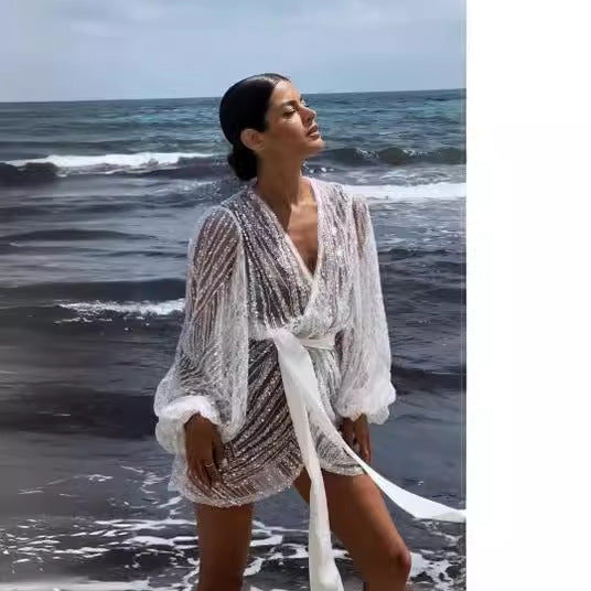 Kvinnors glittrande strandrock med elegant bälte och breda utsvängda ärmar Mirla-Eva Jonsson