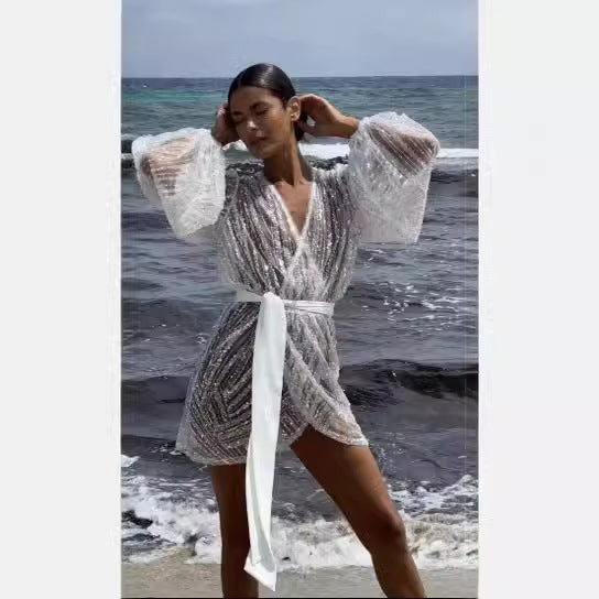 Kvinnors glittrande strandrock med elegant bälte och breda utsvängda ärmar Mirla-Eva Jonsson