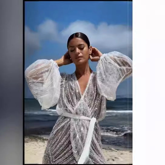 Kvinnors glittrande strandrock med elegant bälte och breda utsvängda ärmar Mirla-Eva Jonsson