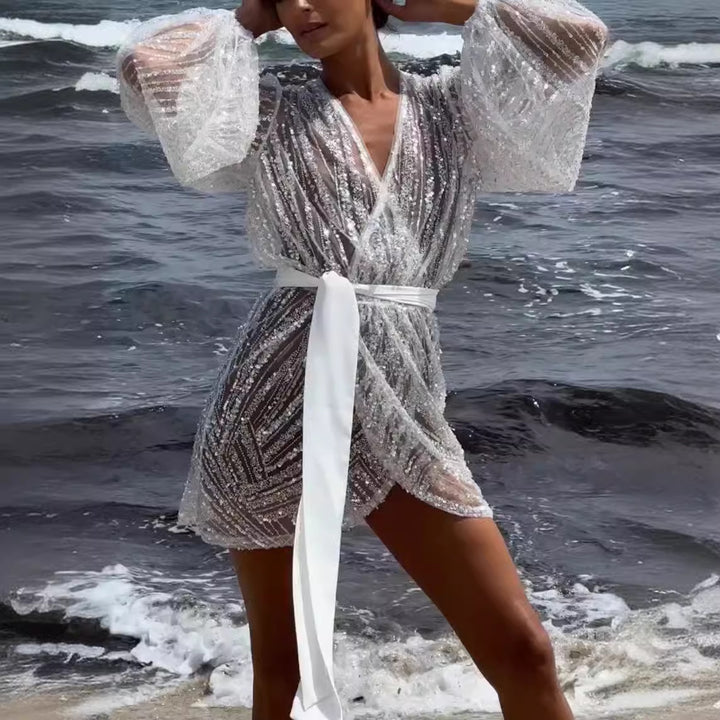 Kvinnors glittrande strandrock med elegant bälte och breda utsvängda ärmar Mirla-Eva Jonsson