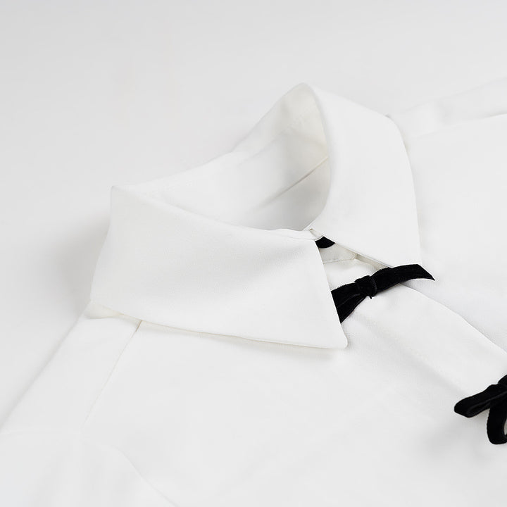 Kvinnors klassiska blus med dekorativa knutar och eleganta detaljer Mirla-Eva Jonsson