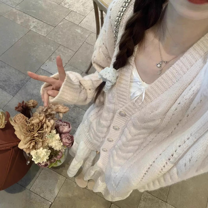 Kvinnors kofta med kabelmönster och blommig detalj Mirla-Eva Jonsson