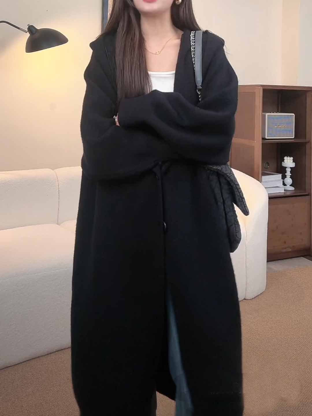 Kvinnors långstickad kappa med avslappnad huva och vida ärmar draperade-Eva Jonsson