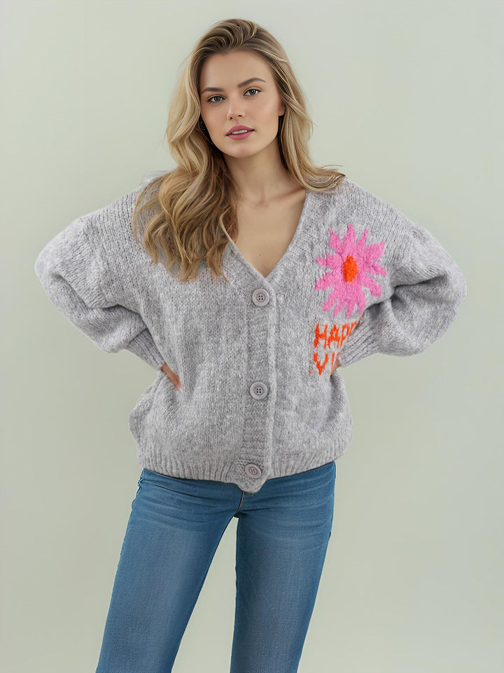 Kvinnors lekfulla kofta med färgglad blomsterdesign och stora knappar Mirla-Eva Jonsson