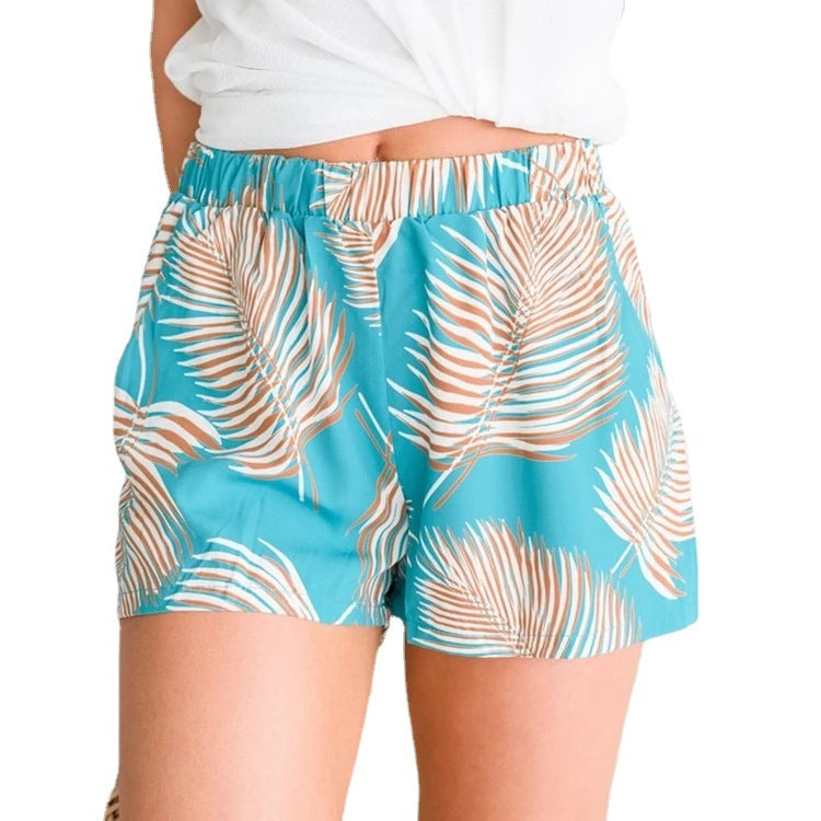 Kvinnors luftiga strandshorts med elastisk midja och tropiskt bladdesign-Eva Jonsson