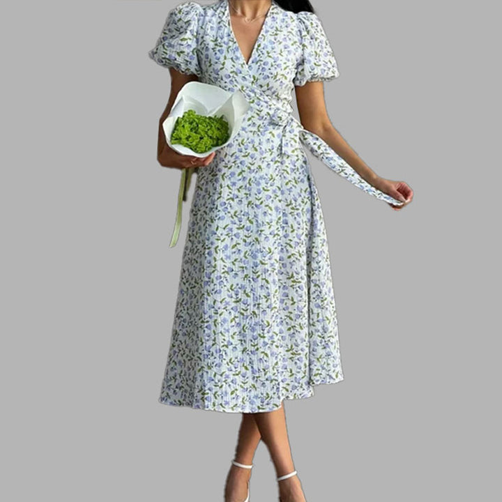 Kvinnors omslagklänning med voluminösa puffärmar och blommiga utsmyckningar Mirla-Eva Jonsson