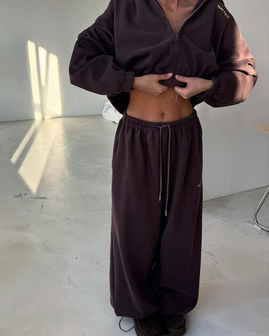 Kvinnors sportiga fritidsoutfit med kort hoodie och vida joggers Mirla-Eva Jonsson